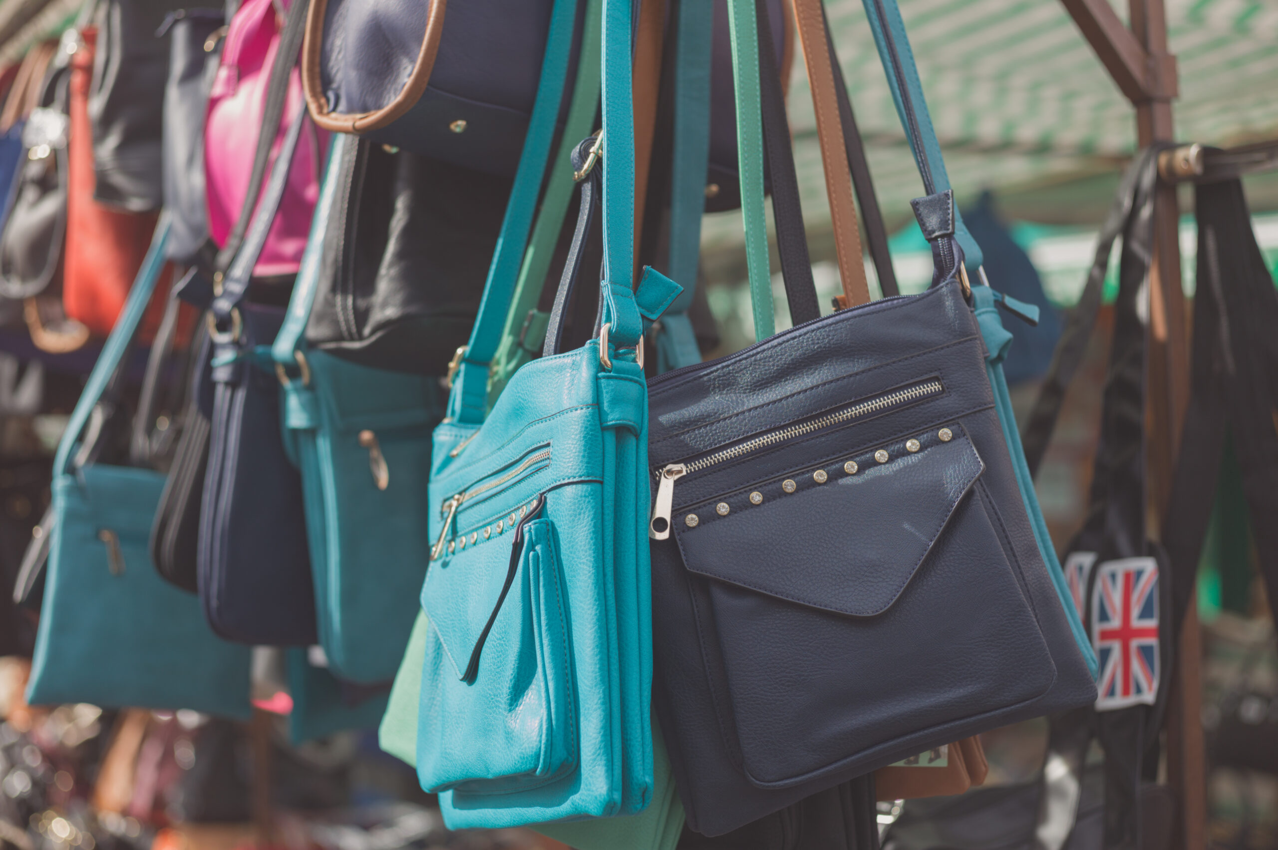 Blue and purple handbags on display in marketplace